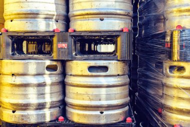 Bira fıçıları gün ışığı görünümüne siyah plastik palet üzerinde. Sıcak sarı güneşin çelik yansıtan. Limassol, Kıbrıs