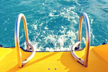 Gün ışığından yararlanma üst görünümden sarı tekne merdiveni. Kristal mavi su hızı sıçramasına. Protaras, Kıbrıs