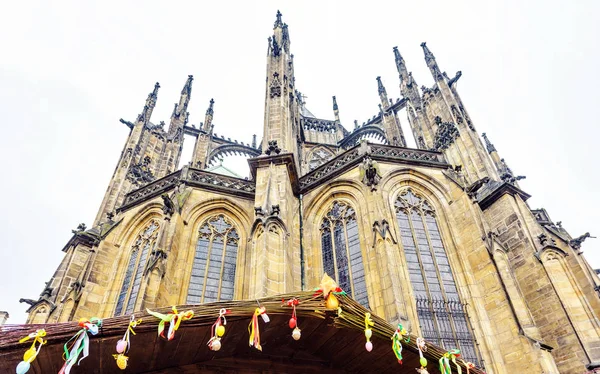 Gothic architectured St. Vitus Cathedral from bottom in a cloudy day. Easter ornamented wood stalls roof. Negative copy space, place for text. Prague, Czech Republic