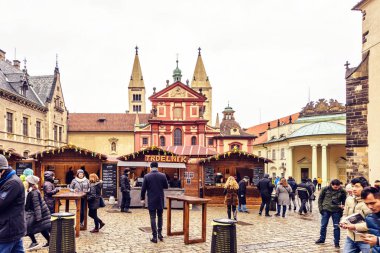 Prag, Çek Cumhuriyeti - 23 Mart 2018: St George's Bazilikası'nın önünde geleneksel gıda tezgahları. Yürüyen ve konuşan insanlar. Negatif kopya alanı, metin için yer. Bulutlu gün