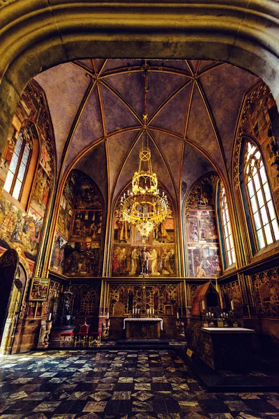 Prague, Çek Cumhuriyeti - 23 Mart 2018: Gotik mimarisinin iç St. Vitus Katedrali ile sıcak parlayan windows ve Pyres asılı. Duvarlara resim sergisi
