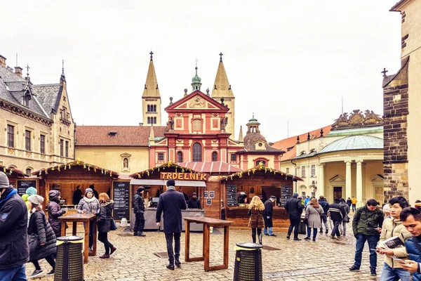 Prag, Çek Cumhuriyeti - 23 Mart 2018: St George's Bazilikası'nın önünde geleneksel gıda tezgahları. Yürüyen ve konuşan insanlar. Negatif kopya alanı, metin için yer. Bulutlu gün