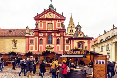 Prag, Çek Cumhuriyeti - 23 Mart 2018: St George's Bazilikası'nın önünde geleneksel gıda tezgahları. Yürüyen ve konuşan insanlar. Negatif kopya alanı, metin için yer. Bulutlu gün