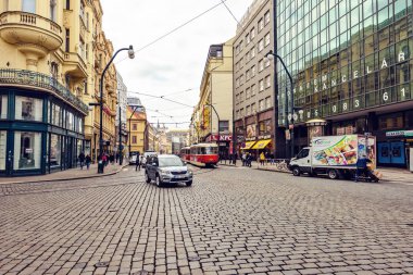 Prague, Çek Cumhuriyeti - 24 Mart 2018: kaldırımda yürüyen insanlar. Arabalar ve eski tramvay yolda sürme. Eski mimari yapılar yansıtan parlak güneş