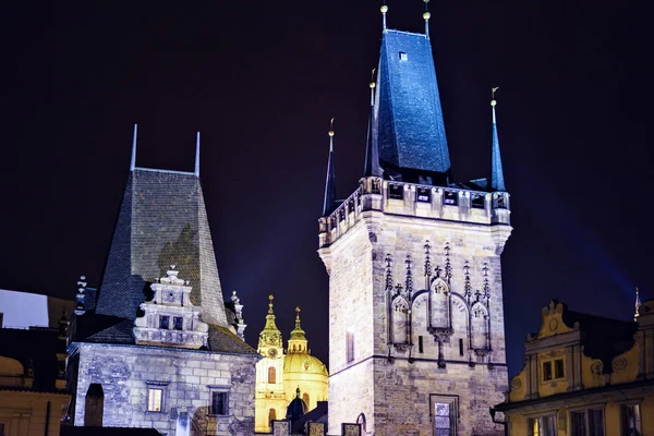 Two castle tower at night near Lesser Town square. St. Nicholas Church on background. Negative copy space, place for text. Prague, Czech Republic