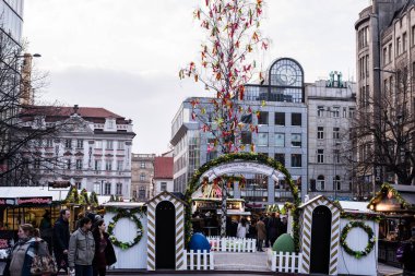 Prag, Çek Cumhuriyeti - 24 Mart 2018: Paskalya ile yiyecek ya da Hatıra Eşyası günbatımında Wenceslas Meydanı'nda stop etti. Modern bina ile arka plan üzerinde yuvarlak masa saati.