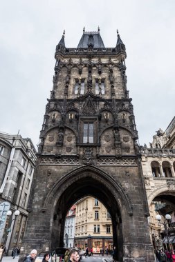 Prague, Çek Cumhuriyeti - 24 Mart 2018: barut Kulesi'nin bulutlu ve yağmurlu bir gün içinde alttan. İnsanlar sokaklarda yürüyen ve yerel turistik yerlerini keşfetmek.