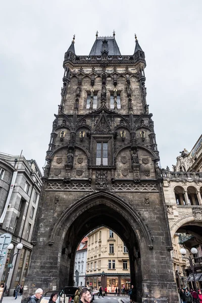 Prague, Çek Cumhuriyeti - 24 Mart 2018: barut Kulesi'nin bulutlu ve yağmurlu bir gün içinde alttan. İnsanlar sokaklarda yürüyen ve yerel turistik yerlerini keşfetmek.