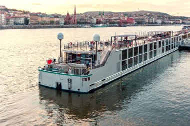 Tuna Nehri yolcu gemisinde gün batımında. Sıcak gökyüzü su yansıtan. Reform Kilisesi ve arka plan üzerinde şehir. Budapeşte, Macaristan