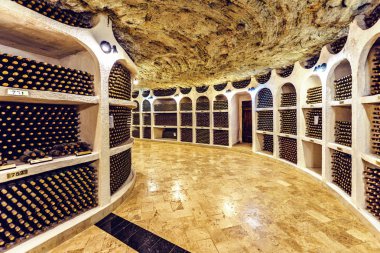 Famous wine cellars in wide perspective. Bright lights illuminating interior. Old stone ceiling. Cricova, Moldova clipart
