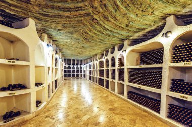 Famous wine cellars in wide perspective. Bright lights illuminating interior. Old stone ceiling. Cricova, Moldova clipart