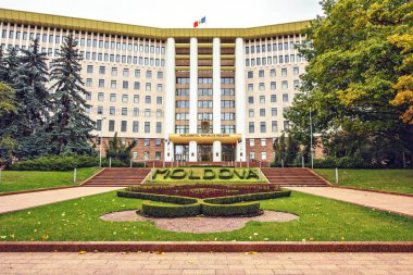 Bulutlu bir günde ülkenin parlamentosu geniş atış. Küçük bahçe önünde çiçeklenir. Kişinev, Moldova