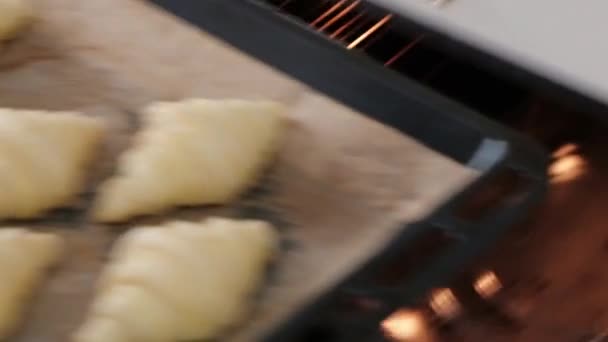 女厨师烤牛角面包在白色烤箱在厨房里 — 图库视频影像