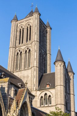 Aziz Nikolaos Kilisesi günbatımı görünümüne. Sıcak güneş bina ve parlak yansıtan gökyüzü arka plan üzerinde. Ghent, Belçika