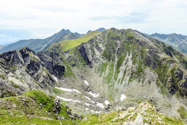 Yaz sezonu Fagaras dağlarda kar Vadisi. Bulutlu gökyüzü arka plan üzerinde. Romanya