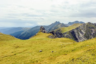 Bulutlu bir günde Paltinului eyer. Yeşil çim ve parlak gökyüzü. Fagaras dağlar, Romanya