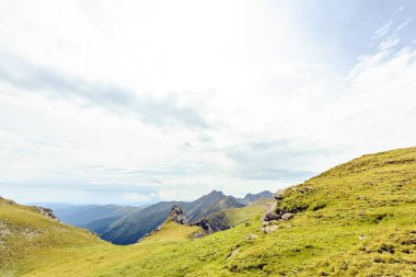 Bulutlu bir günde Paltinului eyer. Yeşil çim ve parlak gökyüzü. Fagaras dağlar, Romanya