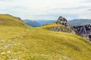 Bulutlu bir günde Paltinului eyer. Yeşil çim ve parlak gökyüzü. Fagaras dağlar, Romanya