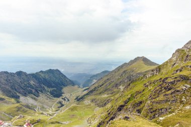 Balea Lake Fagaras dağlar, Romanya'da yakınındaki serpantin yol toplayan. Bulutlu gökyüzü. Geniş çekim