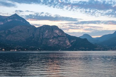 Gün batımında Dağları ile Como Gölü. Bulutlar gökyüzü üzerinde. Sıcak ışık su yansıtan. Bellagio, İtalya
