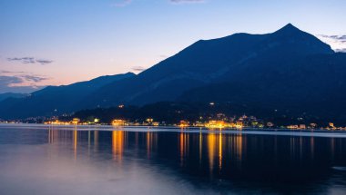 Gün batımında Dağları ile Como Gölü. Şehir ışıkları parlayan. Sıcak ışık su yansıtan. Bellagio, İtalya