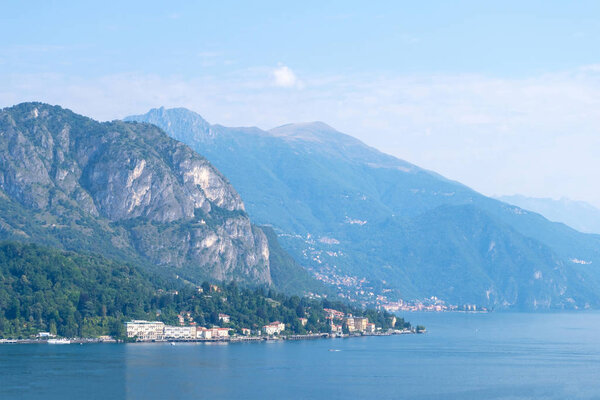 Lake Como with mountains and city buildings. Blue sky on background. Bellagio, Italy
