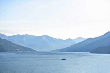 Yalnız vapur Como Gölü üzerinde seyir. Arka planda dağlar siluet. Metin için yer. İtalya güzellikleri
