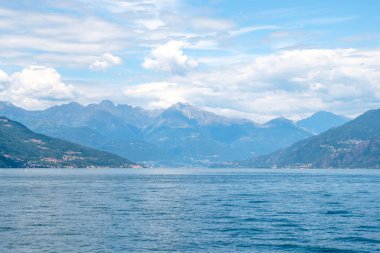 Dağlar ve bulutlu gökyüzü ile Como Gölü. Bellagio, İtalya'dan görünüm