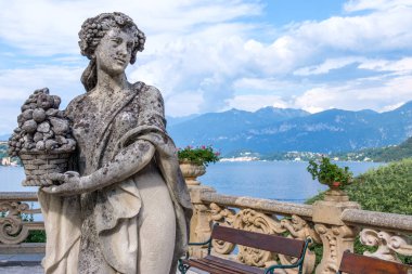 Bir kadının güzel Heykel bahçesinde Villa Balbianello. Lake Como, dağlar ve mavi gökyüzü arka plan üzerinde. Güneşli bir gün. İtalya güzellikleri