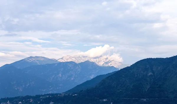 White mountains far away from Lake Como. Cloudy sky. Lenno, Italy