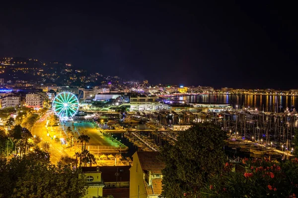 City and port at night. Ferris wheel and street lights. Cannes, France