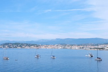 Ships on water at daylight. Vibrant blue water and sky. Place for text. Cannes, France clipart