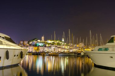 Yatlar Port Cannes deki gece park. Sıcak ışık su yansıtan şehirden. Fransa güzellikleri