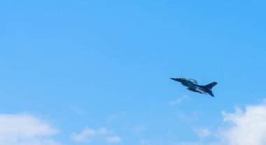 Üzerinde mavi gökyüzü uçan askeri uçak