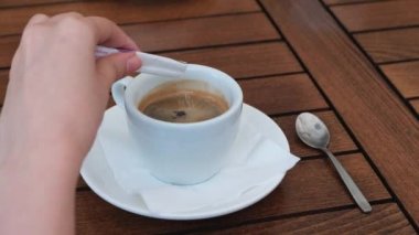 Bir restoran masada siyah kahve şeker ekleyerek kadın