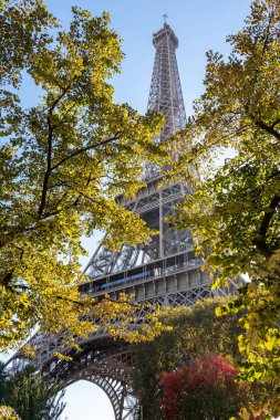 Eyfel Kulesi için ağaçların arasından görüntüleyin. Şehrin aşıkların romantik atmoshpehere. Sonbahar zaman. Paris, Fransa