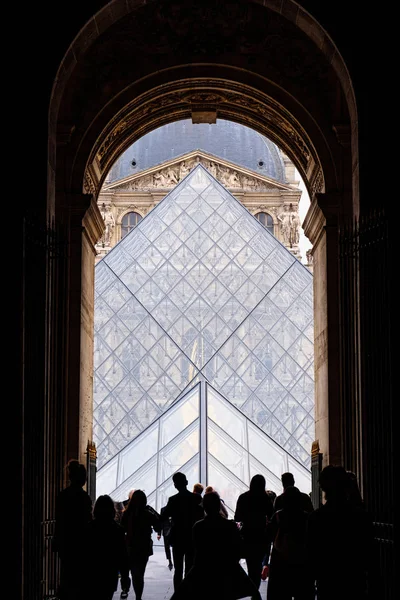 ルーブル美術館の門を通って入る人に垂直方向のショット 対称型のショット フランスでの観光場所 — ストック写真