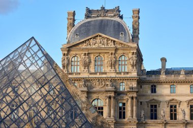 Louvre Müzesi cephe gün batımında. Ön plan üzerinde piramit. Paris, Fransa