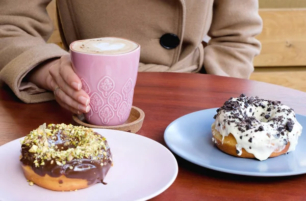 çikolata ve kahve ile çizilmiş bir kalp çörek yeme bir kadın. Kişinev, Moldova