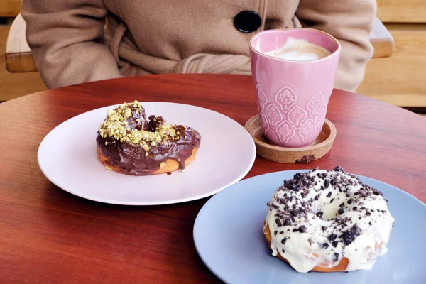 çikolata ve kahve ile çizilmiş bir kalp çörek yeme bir kadın. Kişinev, Moldova