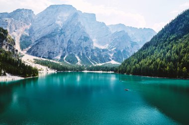 Pragser Wildsee 'de gündüz vakti. Arka planda yeşil orman var. Teknedeki insanlar. Güney Tyrol, İtalya