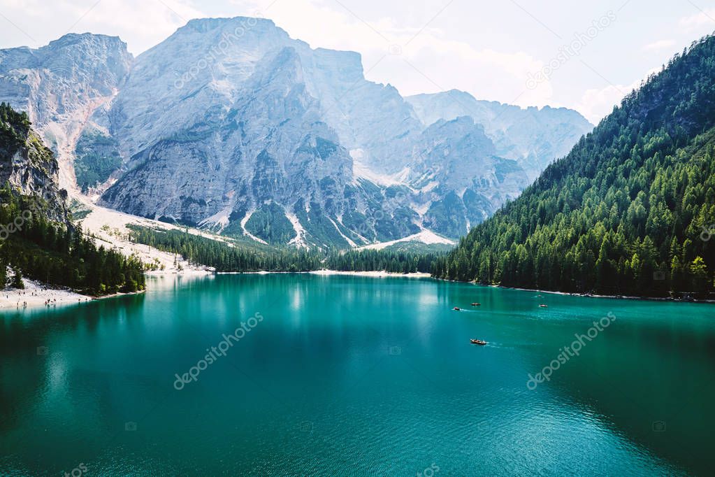The Pragser Wildsee at daylight. Green forest on background. People on boats. South Tyrol, Italy