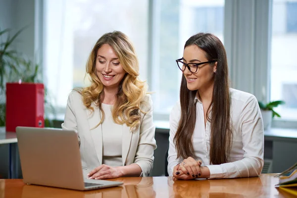 会議室の女性たちはオフィスのノートパソコンでビジネスプランを話し合ってる 背景に働く労働者 — ストック写真