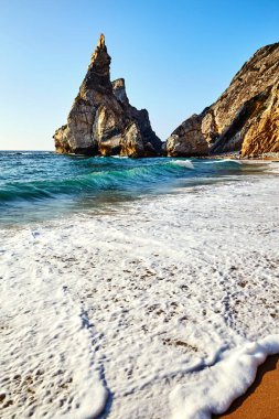 Kayaların üzerinde arka plan büyük ayı plaj sahil şeridine. Lisbon, Portekiz