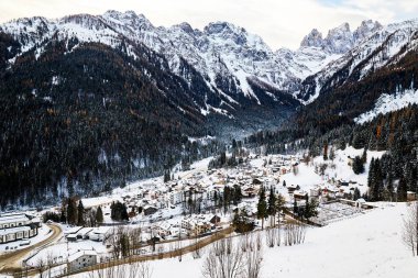 San Martino di Castrozza resort at daylight. Mountains covered in snow. Trentino, Italy clipart