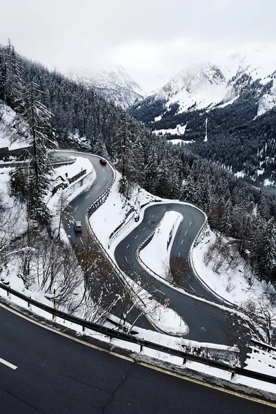 Curved road in the mountains covered in snow. Switzerland