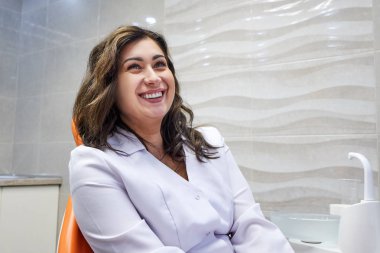 Diş kabine sandalyede oturan genç kadın diş hekimi