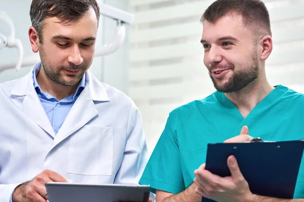 Deux dentistes masculins caucasiens analysant les rayons X — Photo