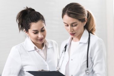 Beyaz kat diş hekimliği Merkezi Birbirinizle konuşmak giymiş iki kadın yardımcıları