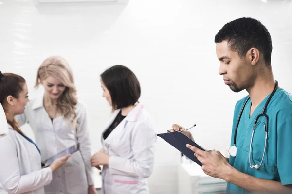 Männer in cyanfarbenem Zahnmantel machen sich Notizen — Stockfoto